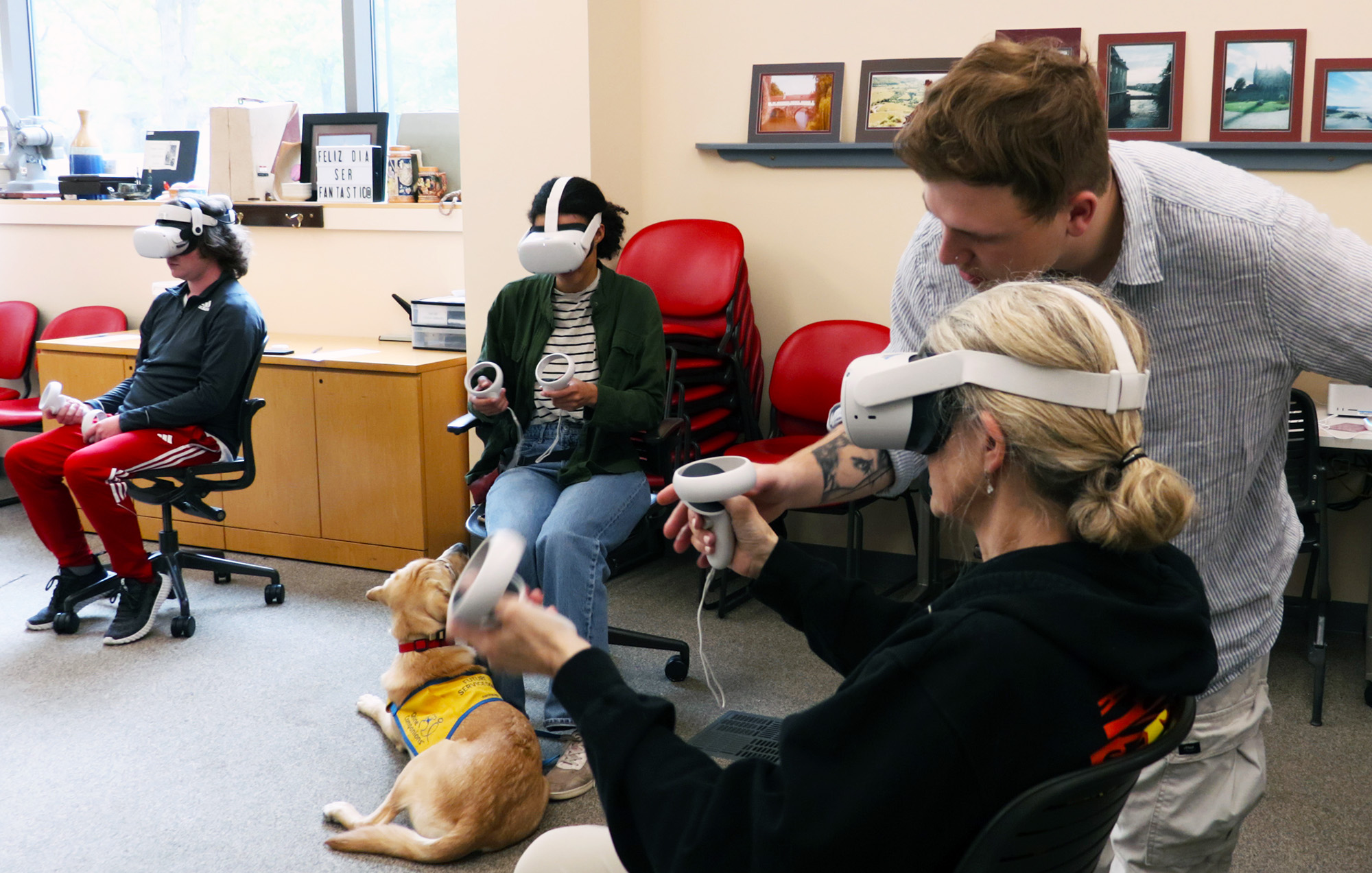 Studio intern Isaiah Nies assisting an Italian 2003 student with a VR headset.